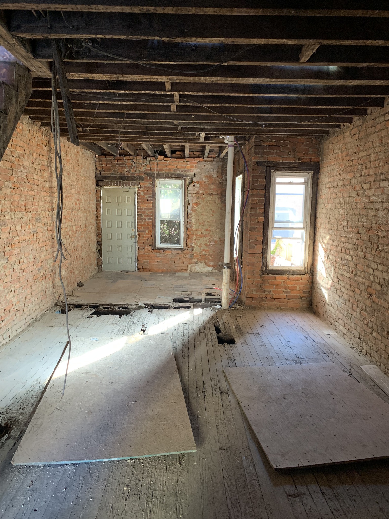 Fully gutted house interior with exposed brick — bought as-is